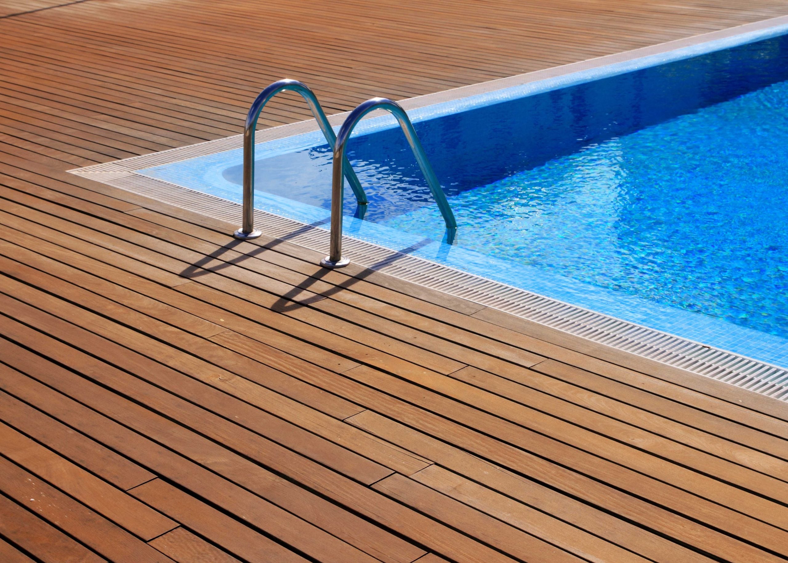 a wrap around deck is installed with a pool on a residential property